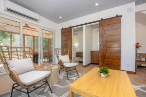 ロアタンにあるCasa Palmera homeの椅子とテーブルのあるリビングルーム
