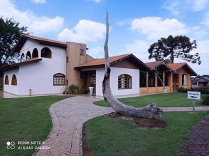 a house with a tree stump in front of it at RECANTO CANTAGALO Hotel in Cantagalo