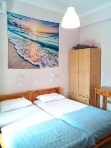 a bedroom with two beds and a painting on the wall at Studios Thomas in Limenaria