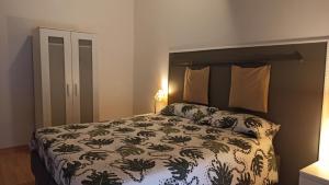 a bedroom with a bed with a green and white comforter at La Picci in Catania