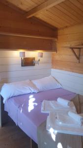 カスタニェート・カルドゥッチにあるAgricamping La Gallinellaの木製の部屋にベッド2台が備わるベッドルーム1室