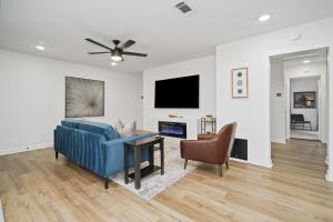 sala de estar con sofá azul y mesa en The Gated Modern Home Near NRG and Medical Center en Houston