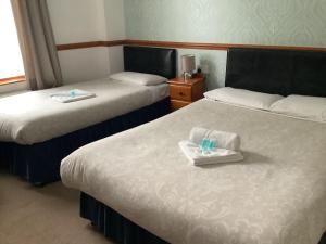 ein Hotelzimmer mit 2 Betten und Handtüchern darauf in der Unterkunft Dover's Restover Bed & Breakfast in Dover