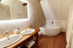 La salle de bains est pourvue de 2 lavabos, d'une baignoire et d'un miroir. dans l'établissement DOMAINE DES LUMIERES, à Aisonville-et-Bernoville