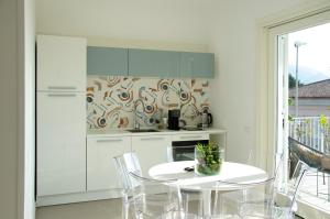 a white kitchen with a white table and chairs at Donna Elena Rooms in Sant'Egidio del Monte Albino
