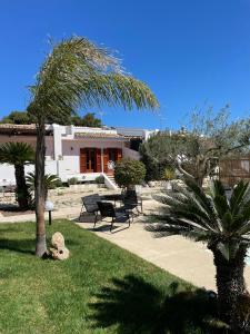 un parque con bancos y palmeras y un edificio en Villa Sara - Villa con piscina, en Marina di Ragusa