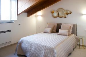 sypialnia z dużym łóżkiem i białymi ścianami w obiekcie Donna Elena Rooms w mieście Sant'Egidio del Monte Albino
