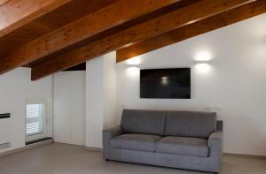 salon z kanapą i telewizorem z płaskim ekranem w obiekcie Donna Elena Rooms w mieście Sant'Egidio del Monte Albino