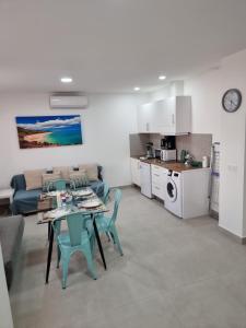 a kitchen and a living room with a table and chairs at APARTAMENTOS ELEMAR free luggage storage in Málaga