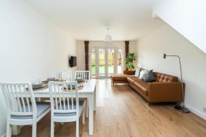 sala de estar con mesa y sofá en Sleek and Stylish 2BD Home with a Garden Anerley, en Londres