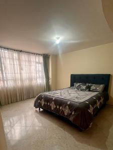 een slaapkamer met een bed in de hoek van een kamer bij CasaBlanca Avcircunvalar in Duitama