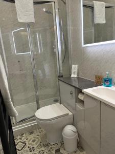 a bathroom with a shower and a toilet and a sink at West End Guest House in Elgin