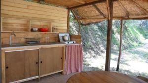 a kitchen in a cabin with a sink and a table at Agricamping La Gallinella in Castagneto Carducci +127 photos