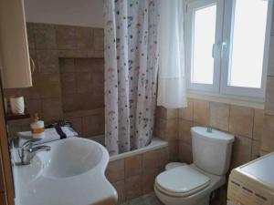 a bathroom with a sink and a toilet and a window at “Marko’s Center Beautiful House” in Corfu +31 photos