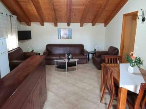 a living room with leather couches and a table at “Marko’s Center Beautiful House” in Corfu