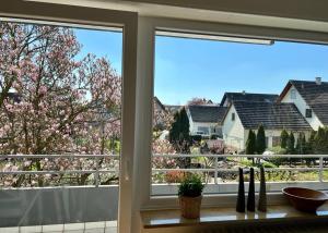 a kitchen window with a view of a flowering tree at Ferienwohnungen Verma in Schwanau
