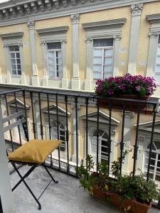 une chaise assise sur un balcon en face d'un bâtiment dans l'établissement Ambra Noblesse, à Naples