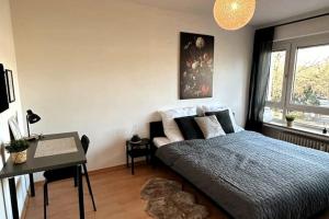 um quarto com uma cama, uma secretária e uma janela em Zitouna Home em Mönchengladbach