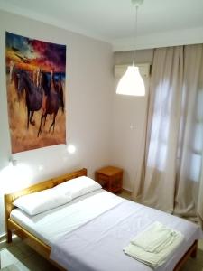 a bedroom with a bed with a painting on the wall at Studios Thomas in Limenaria