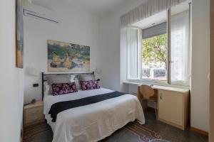 a bedroom with a bed and a desk and a window at Hotel Aida in Alassio