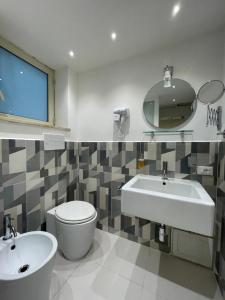 bagno con lavandino, servizi igienici e specchio di Centro Città Basement a Palermo