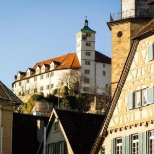 un gran edificio con una torre de reloj en una colina en Im Herzen der Altstadt, en Vaihingen an der Enz