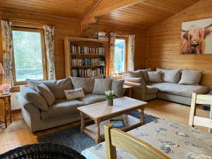 uma sala de estar com um sofá e uma mesa em Valley Lodge em Tiverton