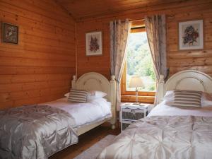Duas camas num chalé com janela em Valley Lodge em Tiverton