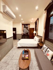 Habitación de hotel con cama y sofá en 櫻花樹夏民宿 en Zhunan