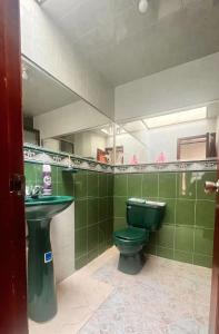 baño con aseo verde y lavamanos en CasaBlanca Avcircunvalar, en Duitama