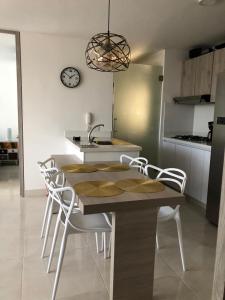a kitchen with a table and chairs and a clock on the wall at Marquis Enclave, Condo With Pool Access and More in Ricaurte