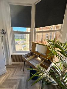 a room with a desk and a tv and two windows at No 3 ,luxury 2 bed 1st floor apartment with free parking,Lytham St Annes in Saint Annes on the Sea