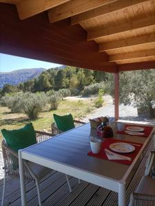 a picnic table on a deck with a view of the mountains at Cabañas by Torre de Arriba in Benimantell