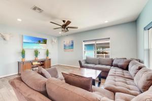 een woonkamer met een grote bank en een plafondventilator bij Big Blue in Port Aransas
