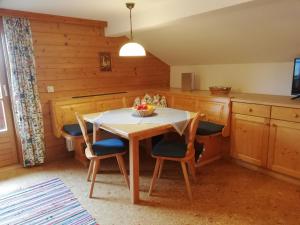 a kitchen with a table and chairs in a room at Vorderkasbichlhof in Saalfelden am Steinernen Meer