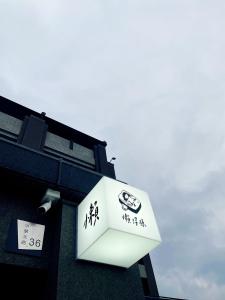 um sinal branco na lateral de um edifício em 懶得棟民宿 em Guanshan