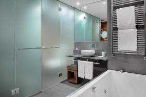 a bathroom with a tub and a sink at Hotel AC Baqueira Ski Resort, Autograph Collection in Baqueira-Beret