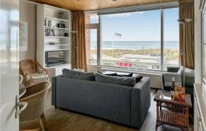 een woonkamer met een bank en uitzicht op de oceaan bij Zwaluwnest in Bergen aan Zee