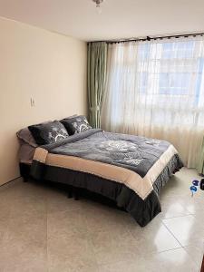 1 cama en un dormitorio con ventana grande en CasaBlanca Avcircunvalar, en Duitama