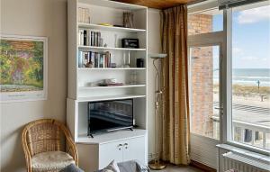 een woonkamer met een tv en een raam bij Zwaluwnest in Bergen aan Zee