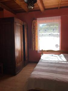 um quarto com uma cama e uma janela em Cottage house-Augustow Primeval Forest, near lake em Płaska