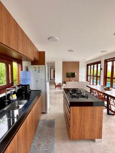 a kitchen with a stove and a refrigerator at Casa Ibiza - Pipa ''Luxurious 3-Bedroom Villa with pool'' in Pipa