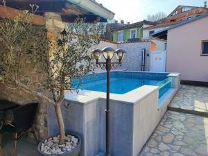 a swimming pool with a light pole and a lamp at Apartment Anitea in Pula