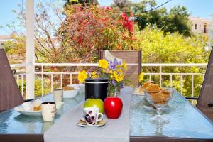 stół z talerzami jedzenia i kwiatów na nim w obiekcie Spentza Home w mieście Spetses