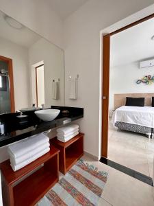 a bathroom with a sink and a bed and a mirror at Casa Ibiza - Pipa ''Luxurious 3-Bedroom Villa with pool'' in Pipa