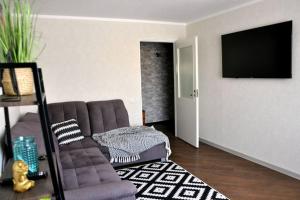 uma sala de estar com um sofá e uma televisão de ecrã plano em Lada Wings 2 em Narva