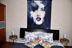 uma pintura de uma mulher está acima de uma cama em Lada Wings 2 em Narva