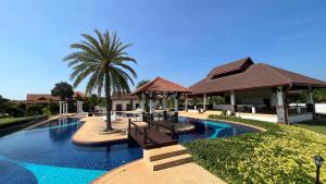 - une piscine avec deux bancs et un palmier dans l'établissement Le Corbusier Style Villa In Green Neighbourhood with Pool, à Mae Pim