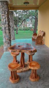 a wooden table and stools in a room at Tu Cabaña en Boquete in Alto Boquete