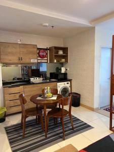 a kitchen with a wooden table and chairs in a kitchen at KUANTAN - TIMURBAY SEAFRONT RESIDENCE a in Kuantan